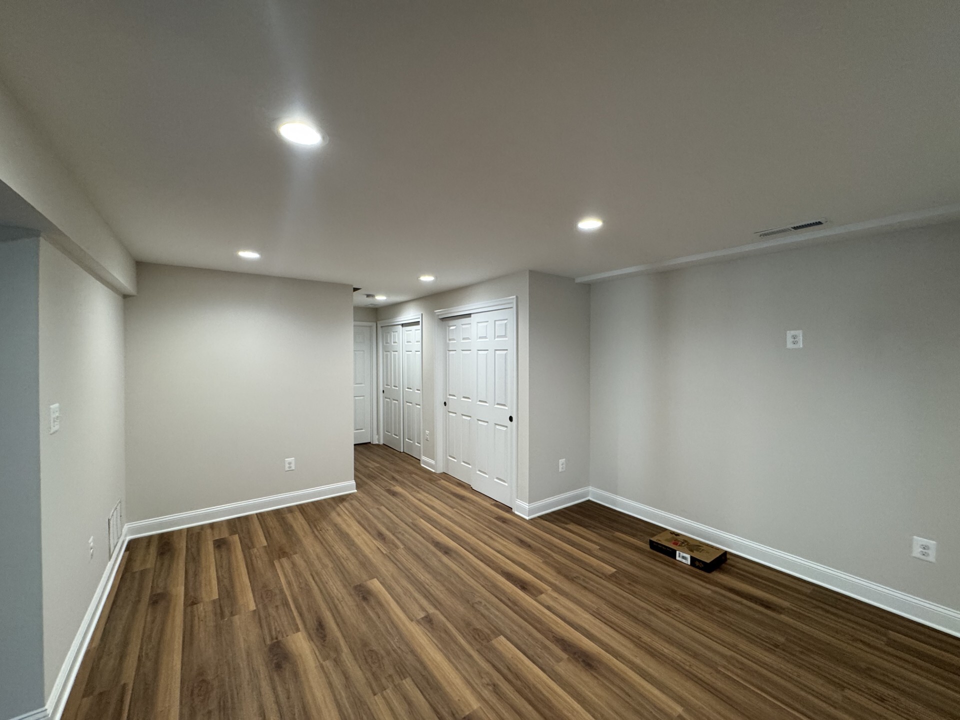 Basement with modern flooring and lighting